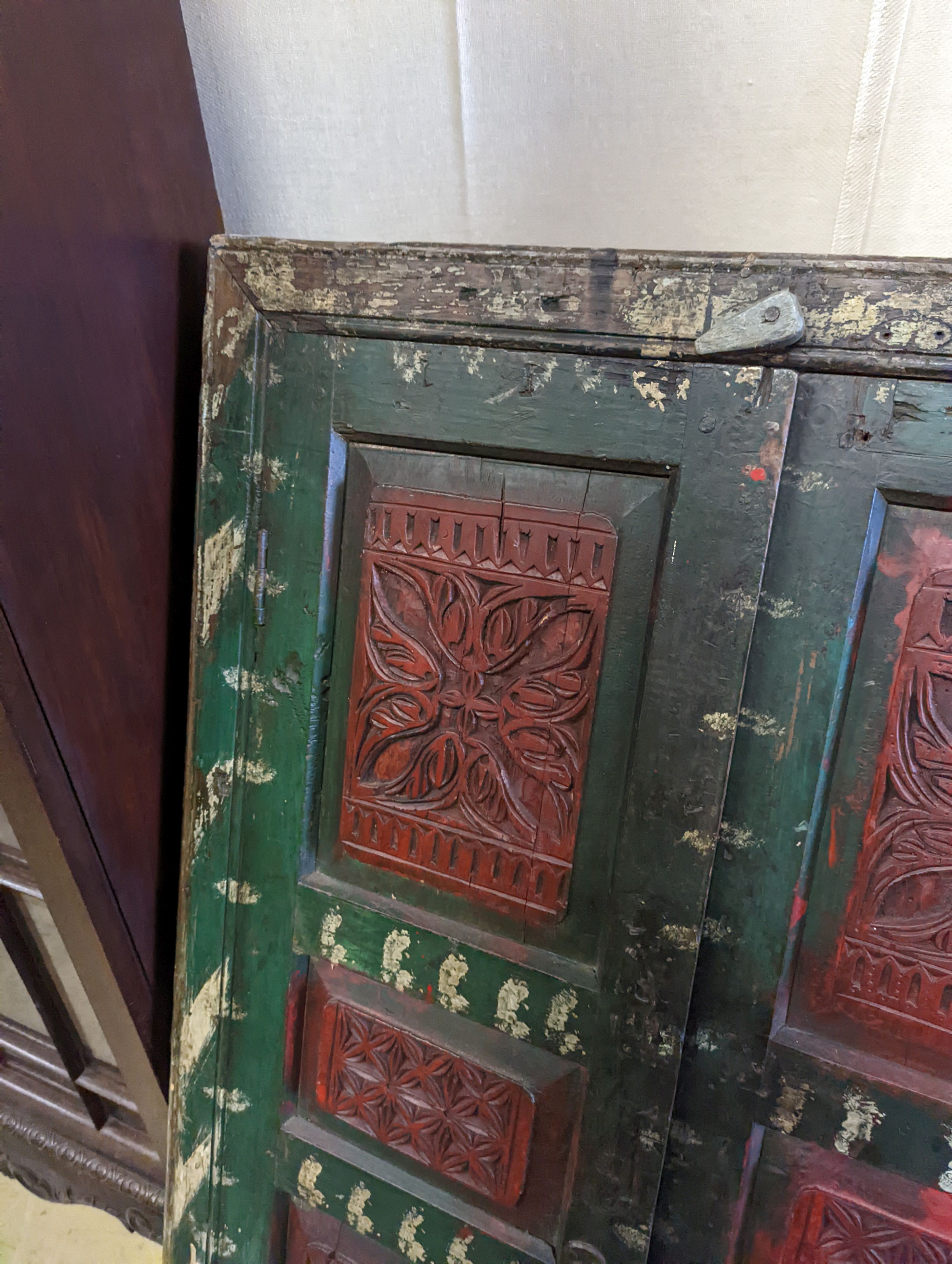 An Afghan painted carved hardwood corner cupboard, width 90cm, height 131cm